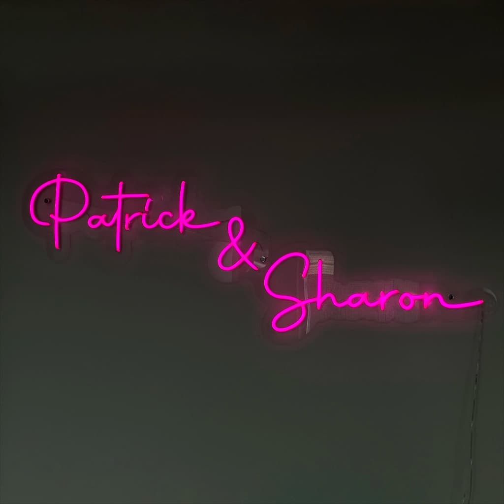 Roze neon naam op maat Patrick en Sharon aan de muur